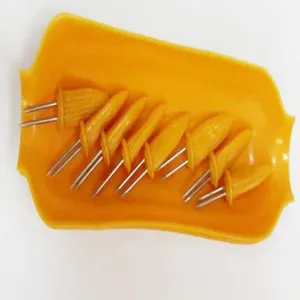 Detailansicht von acht Edelstahl-Maiskolbenhaltern auf einer gelben Maisschale