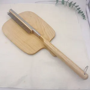 Close-up detail of pizza stone oven brush with wooden handle and steel bristles