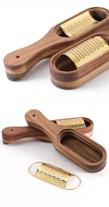 Close-up detail of the removable gold grater plate and handcrafted wooden storage base