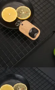 Detail view of a portable oak wooden beer bottle opener on a black grid background