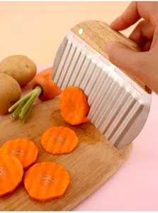 Detailed view of wavy stainless steel crinkle cutter slicing a carrot on a board