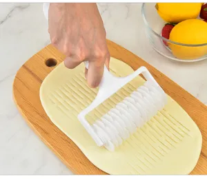 Detailed macro shot of white plastic pizza lattice roller cutter creating patterns on dough