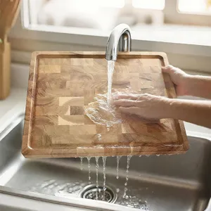Premium square acacia wood end grain cutting board with juice groove being rinsed under water