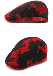 Detailed view of women's retro black beret with red floral embroidery and side buckle