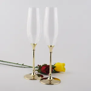 Pair of elegant champagne flutes with gold metal stems and bases for wedding gifts