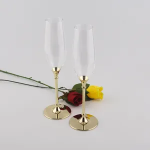 Elegant set of two champagne flutes with gold metal stems and bases for wedding gift.
