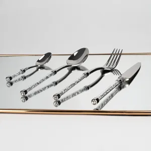 Vue détaillée des poignées luxueuses remplies de cristaux du set de couverts