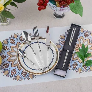 Élégant service de couverts en inox avec manches en cristal sur une table décorée.