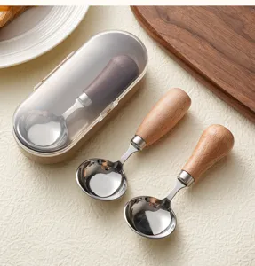Detalle de cucharas redondas de acero inoxidable con mangos de madera y estuche