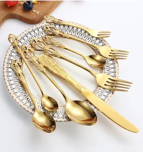 Detalle del exquisito juego de cubiertos vintage dorados con relieve estilo palacio en plato