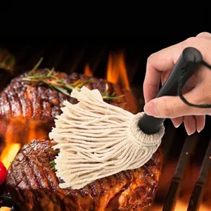 BBQ basting mop brush with black handle and cotton strings used on grilled meat