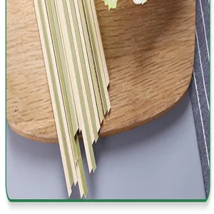 Detailed macro view of flat green-skinned bamboo skewers on a wooden board