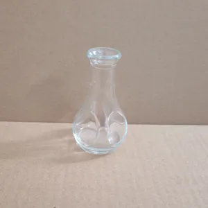 Petit vase en verre transparent avec une base bulbeuse à encoches pour décor de table