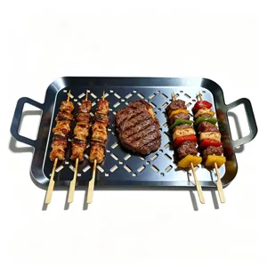 Perforated stainless steel grill pan with double handles holding grilled skewers and steak