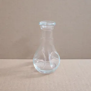 Vue détaillée d'un vase en verre transparent montrant son col étroit et sa base