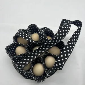 Vista detallada de compartimentos de una bolsa de tela para huevos con lunares negros.