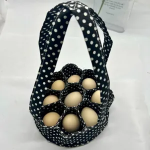 Cesta de lona para recoger huevos con lunares blancos que contiene diez huevos frescos