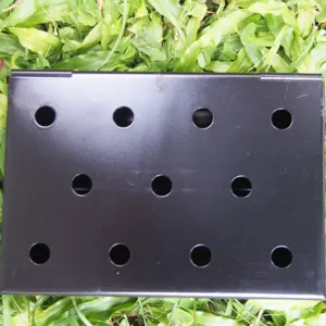 Vista superior de una caja ahumadora de barbacoa de metal negro con 12 orificios