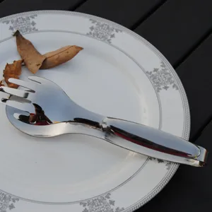 Close-up of mirror polished stainless steel food tongs for steak and salad on a plate
