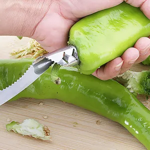 Macro view of stainless steel pepper corer tool extracting seeds from a chili