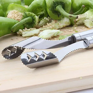 Close-up of a stainless steel pepper corer with serrated edges on a wooden board