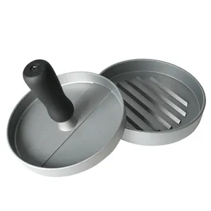 Detail of a circular metal hamburger press with black ergonomic handle on white background.