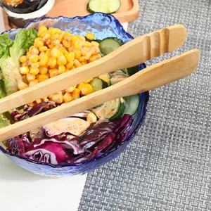 Close-up of eco-friendly bamboo food tongs serving fresh vegetable salad