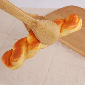 Detail view of eco-friendly bamboo kitchen tongs clamping a fresh bread roll.