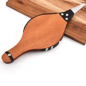 Close-up of wooden BBQ bellows with leather trim and metal rivets for outdoor grill.