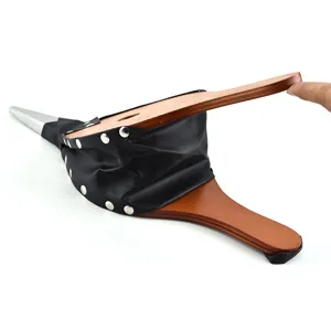 Detailed macro view of hand-operated wooden BBQ bellows showing leather air chamber