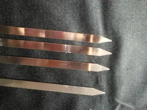 Nahaufnahme von vier flachen Grillspießen aus rostfreiem Edelstahl mit scharfen Spitzen