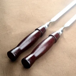 Nahaufnahme von Grillspießen aus Edelstahl mit ergonomischen Griffen aus Rosenholz