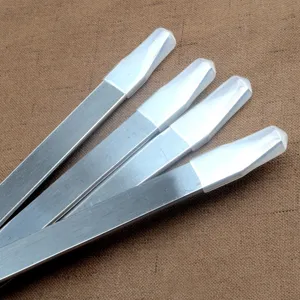 Detailaufnahme flacher Grillspieße aus Edelstahl mit weißen Schutzkappen an der Spitze