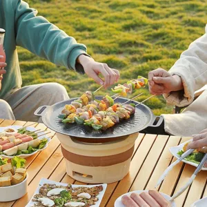 Outdoor non-stick Korean BBQ grill pan with portable clay stove on wooden table