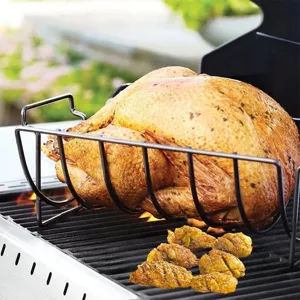 Close-up of a black non-stick metal BBQ roast rack holding a whole turkey on a grill