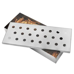 Detalle de la caja ahumadora para barbacoa de acero inoxidable con tapa perforada y virutas.