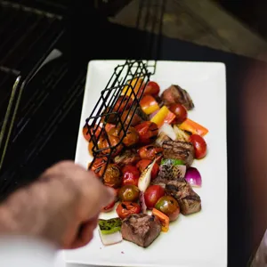 Close-up of a black non-stick barbecue basket used for grilling meat and vegetables