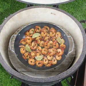 Leckere gegrillte Garnelen mit Limetten in einer schwarzen antihaftbeschichteten Grillpfanne