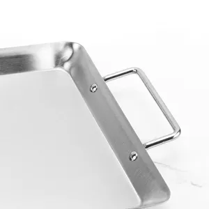 Close-up detail of stainless steel BBQ baking tray handle with secure rivet attachment