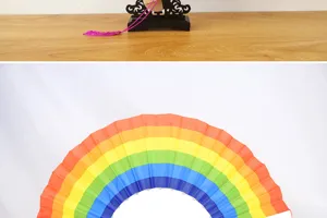 Gros plan d'un support pour éventail en bois et d'un éventail arc-en-ciel.