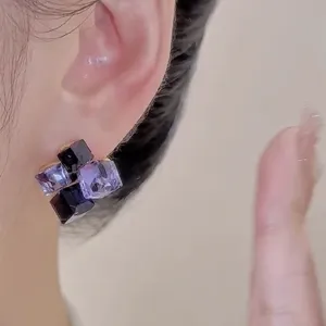 Detailed close-up showing the elegant purple crystal cube stud earrings worn on an ear