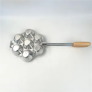 Detalle de un molde de aluminio de 7 orificios para repostería con mango de madera.