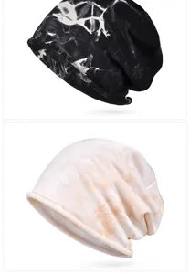 Close-up view of two tie-dye slouchy beanies in black and peach colors with rolled edges