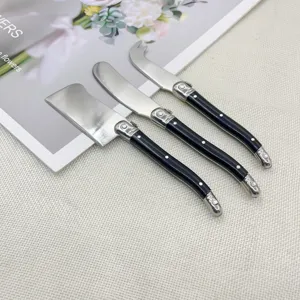 Close-up detail of 3-piece stainless steel cheese knife and butter spreader set with black handles