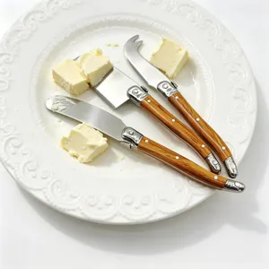 Close-up of 3-piece Laguiole style cheese knife set with wood grain handles