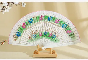 Detalle de abanico español de madera pintado con flores y delicado diseño calado floral