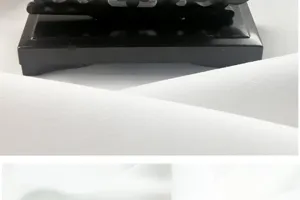 Vue rapprochée d'un socle de support d'éventail pliant noir sur fond de tissu blanc.