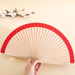 Traditional 23cm solid wood folding fan featuring a vibrant red fabric trim accent