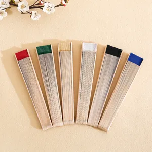 Collection of 23cm solid wood folding fans in various colors on beige background