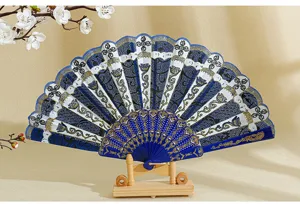 Primo piano di un ventaglio spagnolo pieghevole con motivi floreali blu e oro